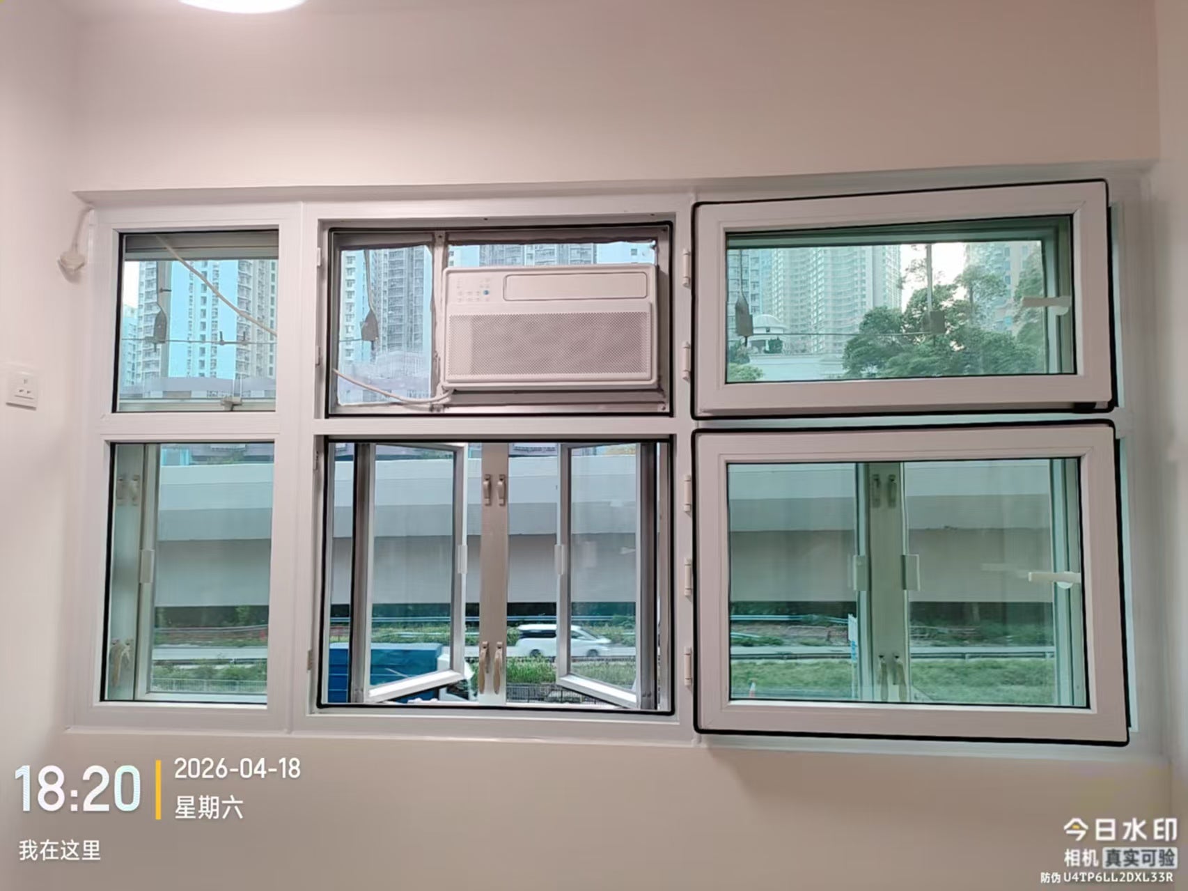 A window assembly around a window air conditioner, showing several sashes in open positions.